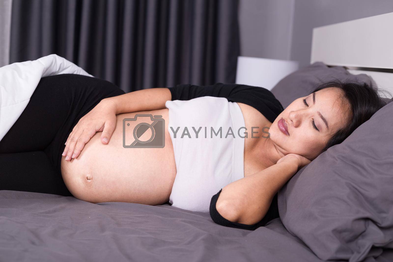 Royalty free image of pregnant woman sleeping on bed in the bedroom by geargodz