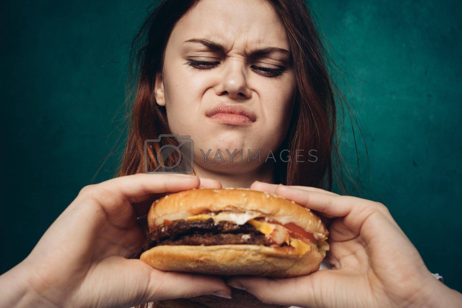woman eating hamburger fast food snack close-up. High quality photo