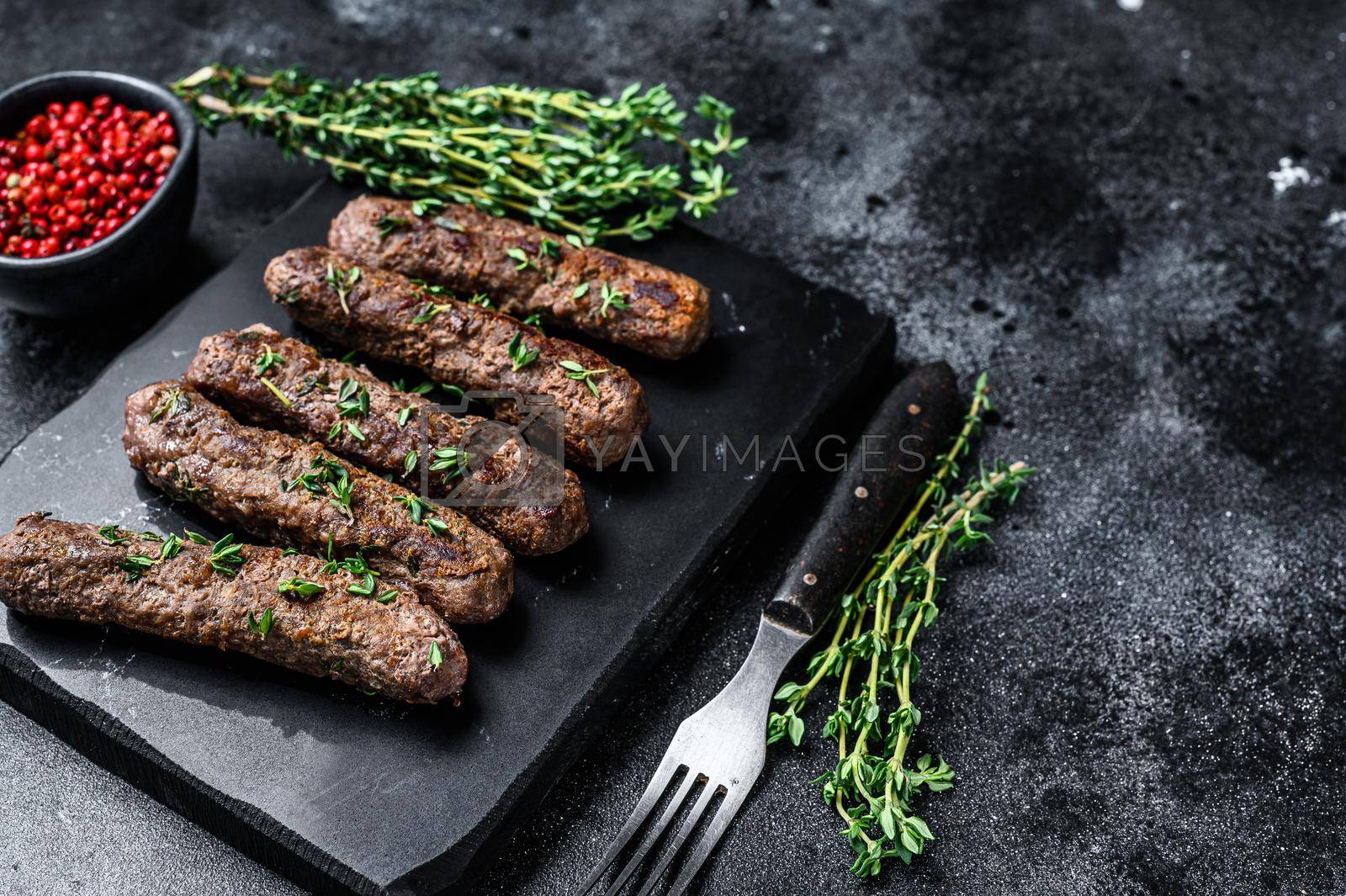 Royalty free image of Grilled Shish kebab meat sausages. Black background. Top view. Copy space by Composter