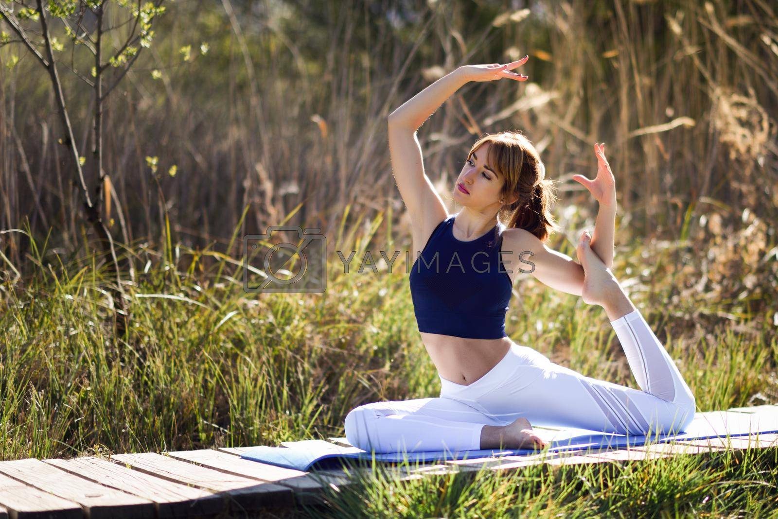 Royalty free image of Young beautiful woman doing yoga in nature by javiindy