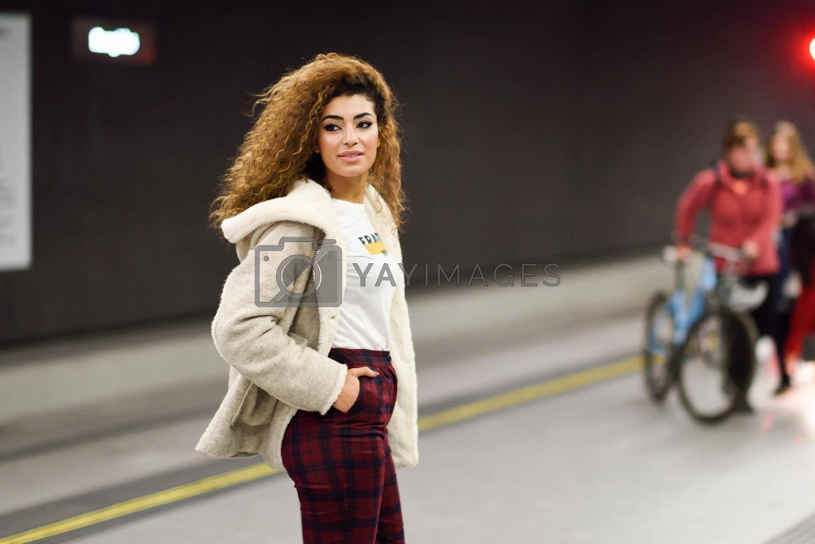 Beautiful young arabic woman waiting her train in a subway station. Arab girl in casual clothes.