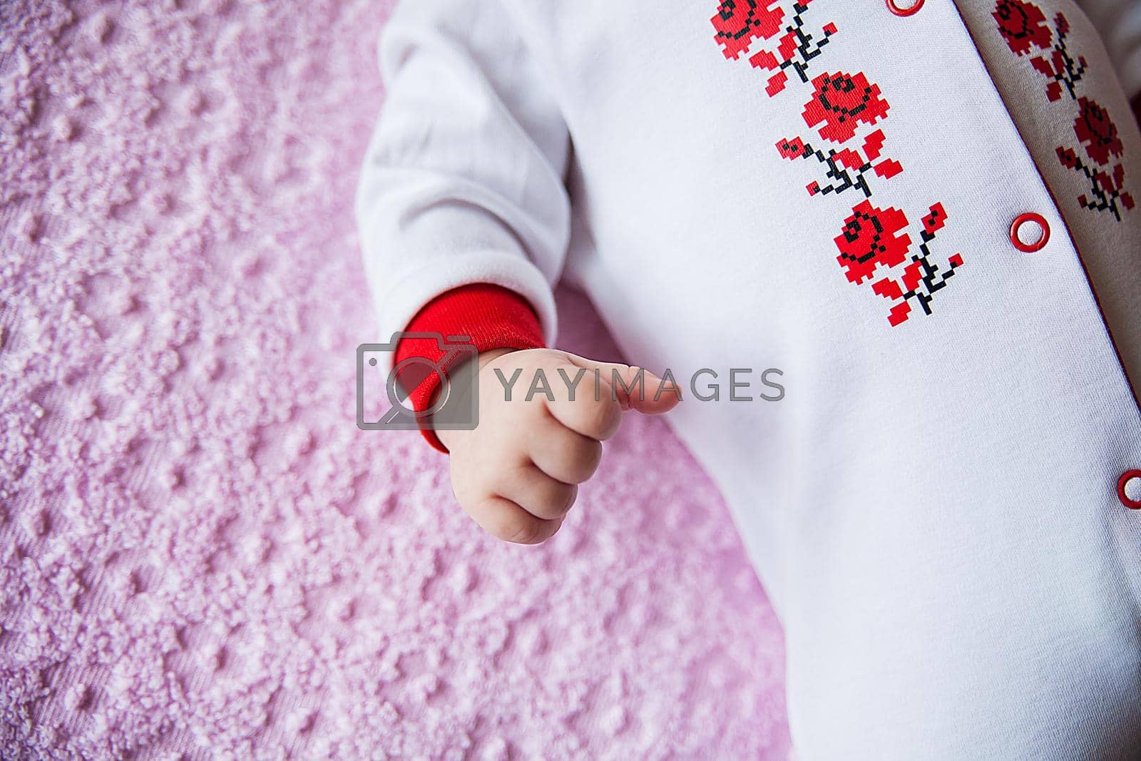 Royalty free image of Newborn baby dressed in costume with embroidery by sfinks