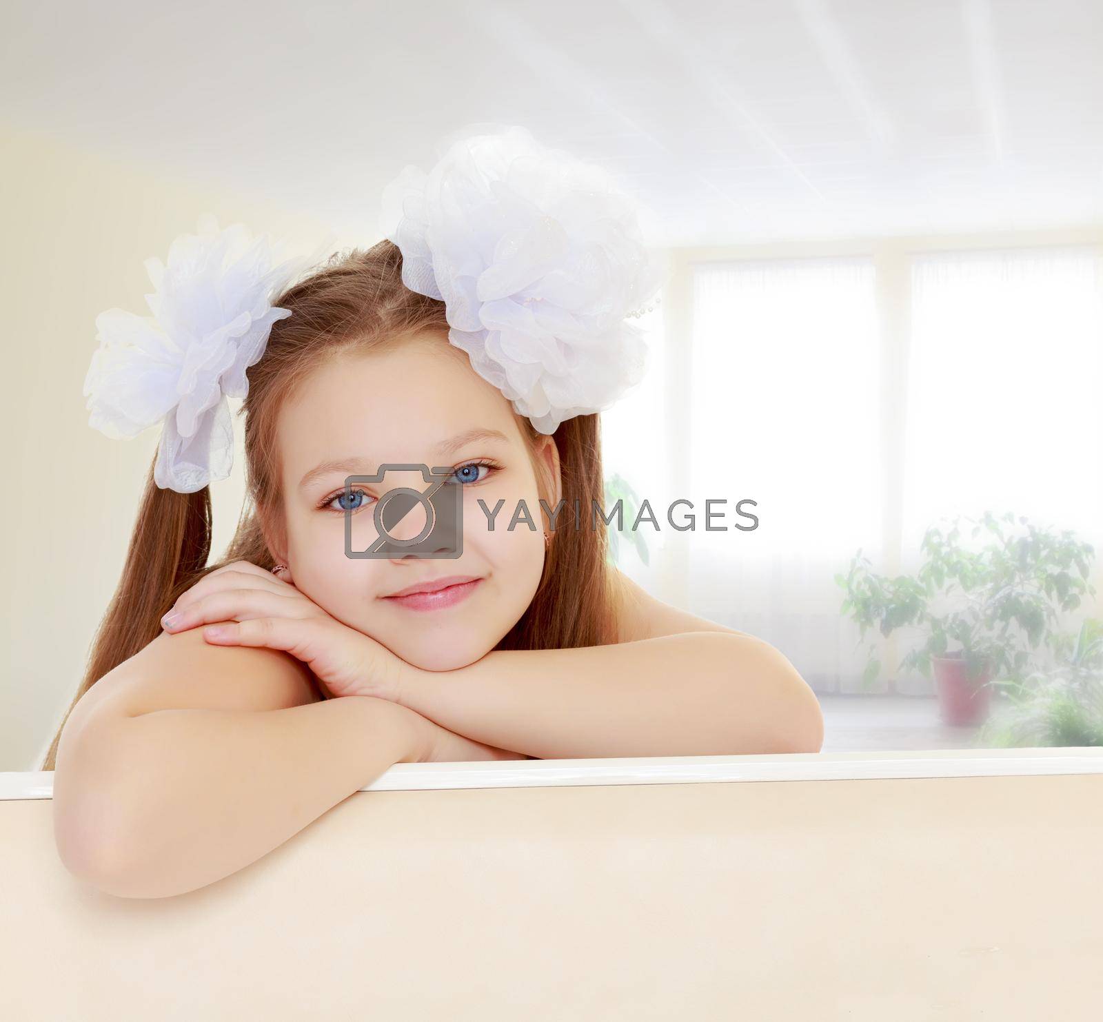 Royalty free image of Beautiful little girl with white bows on the head by kolesnikov_studio