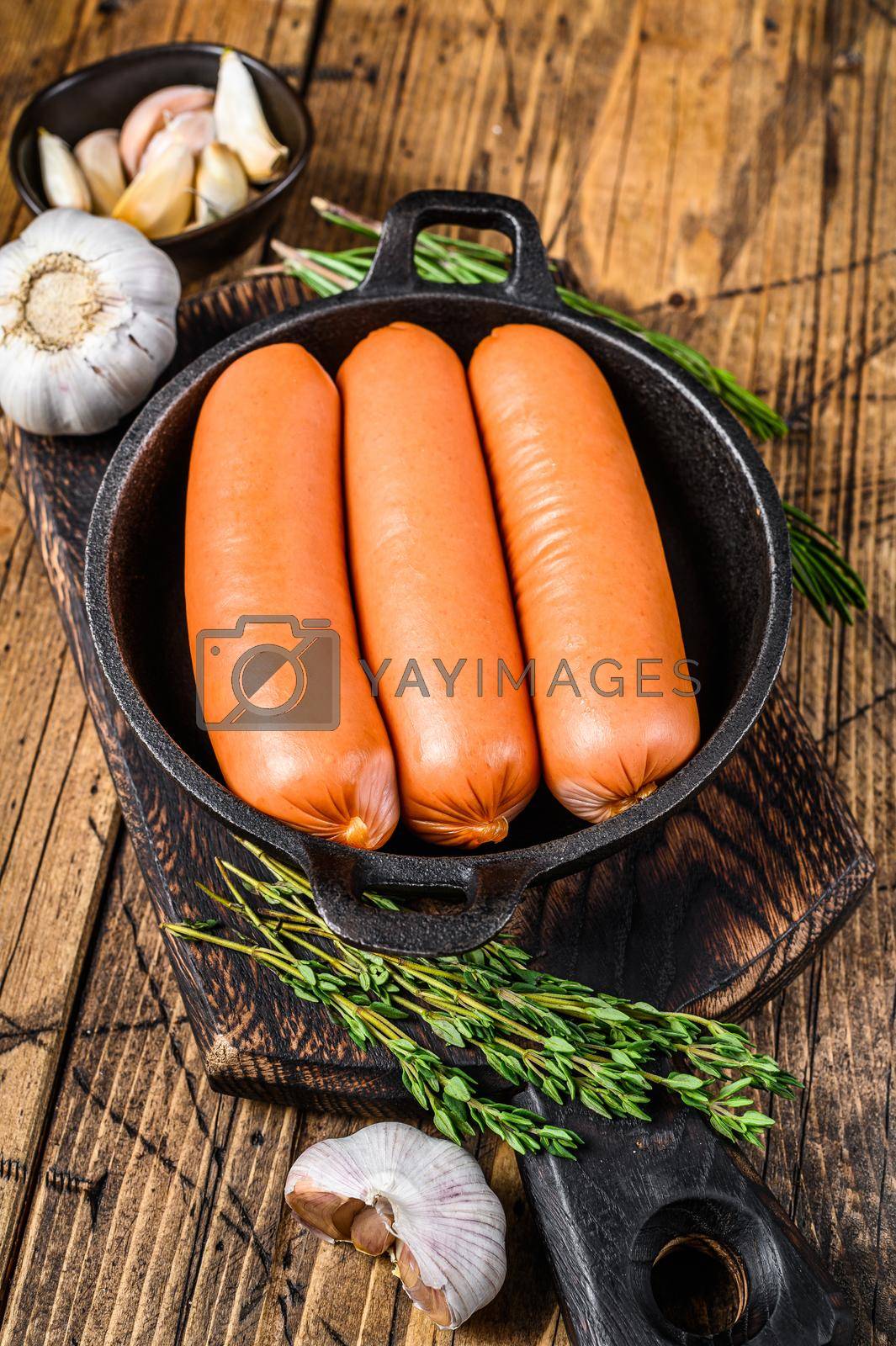 Royalty free image of Sausages bratwurst from pork meat in a pan. wooden background. top view by Composter