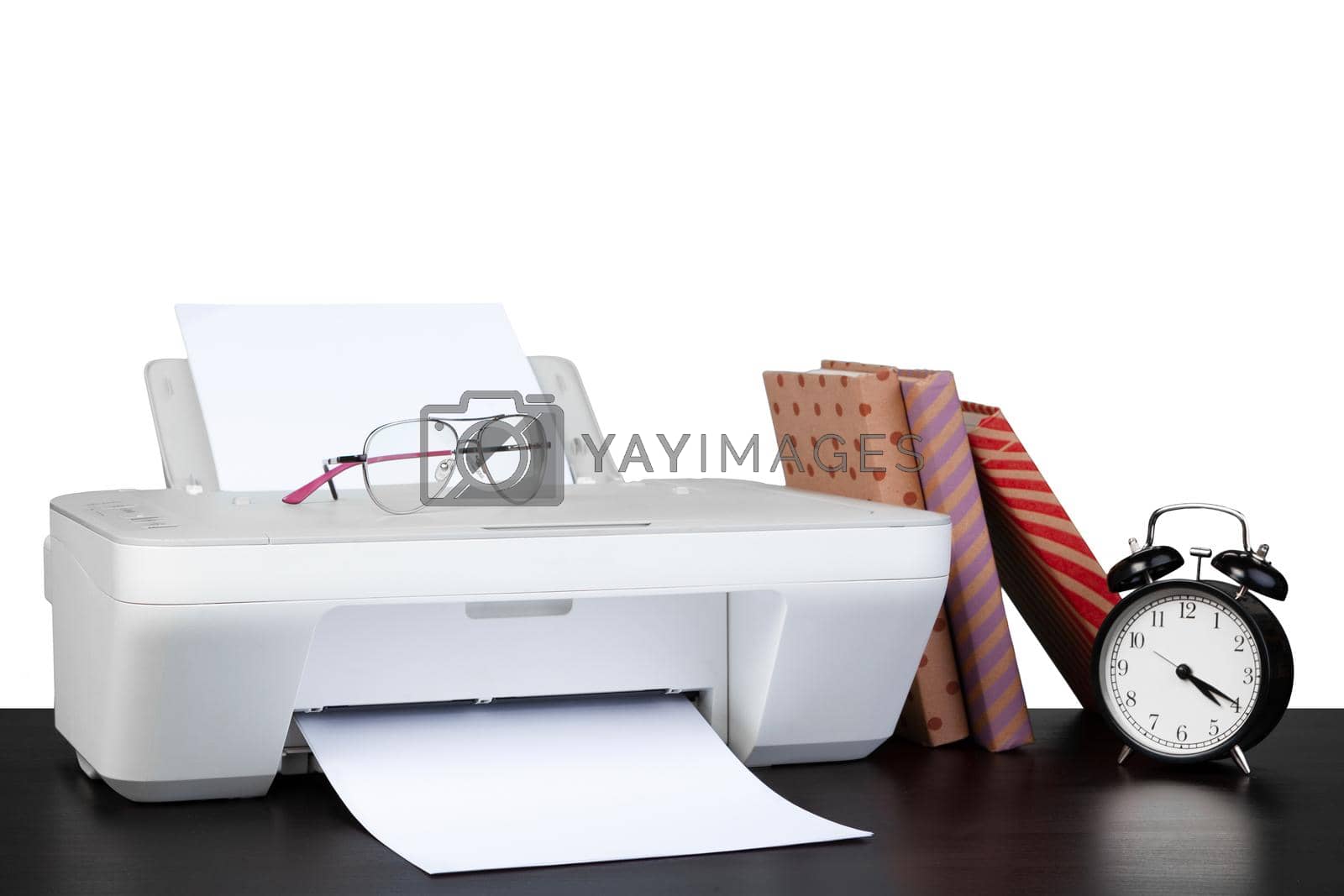 Royalty free image of Printer and stack of books on black table against white background by Fabrikasimf