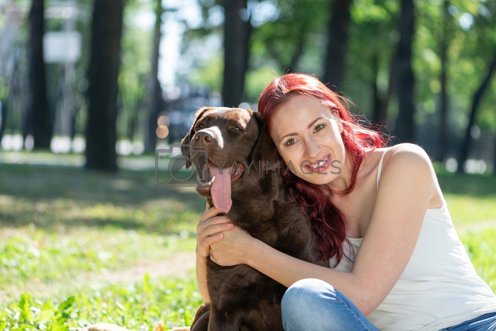 Woman in the park hugs a dog. Spend time with pets