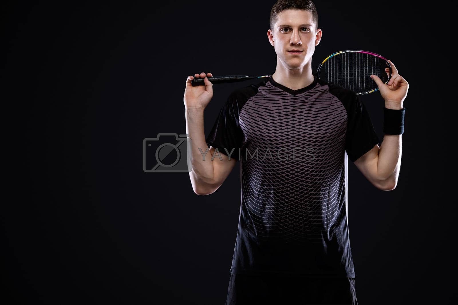 Royalty free image of Badminton player in sportswear with racket and shuttlecock on black background. Individual sports. Sports recreation. by MikeOrlov