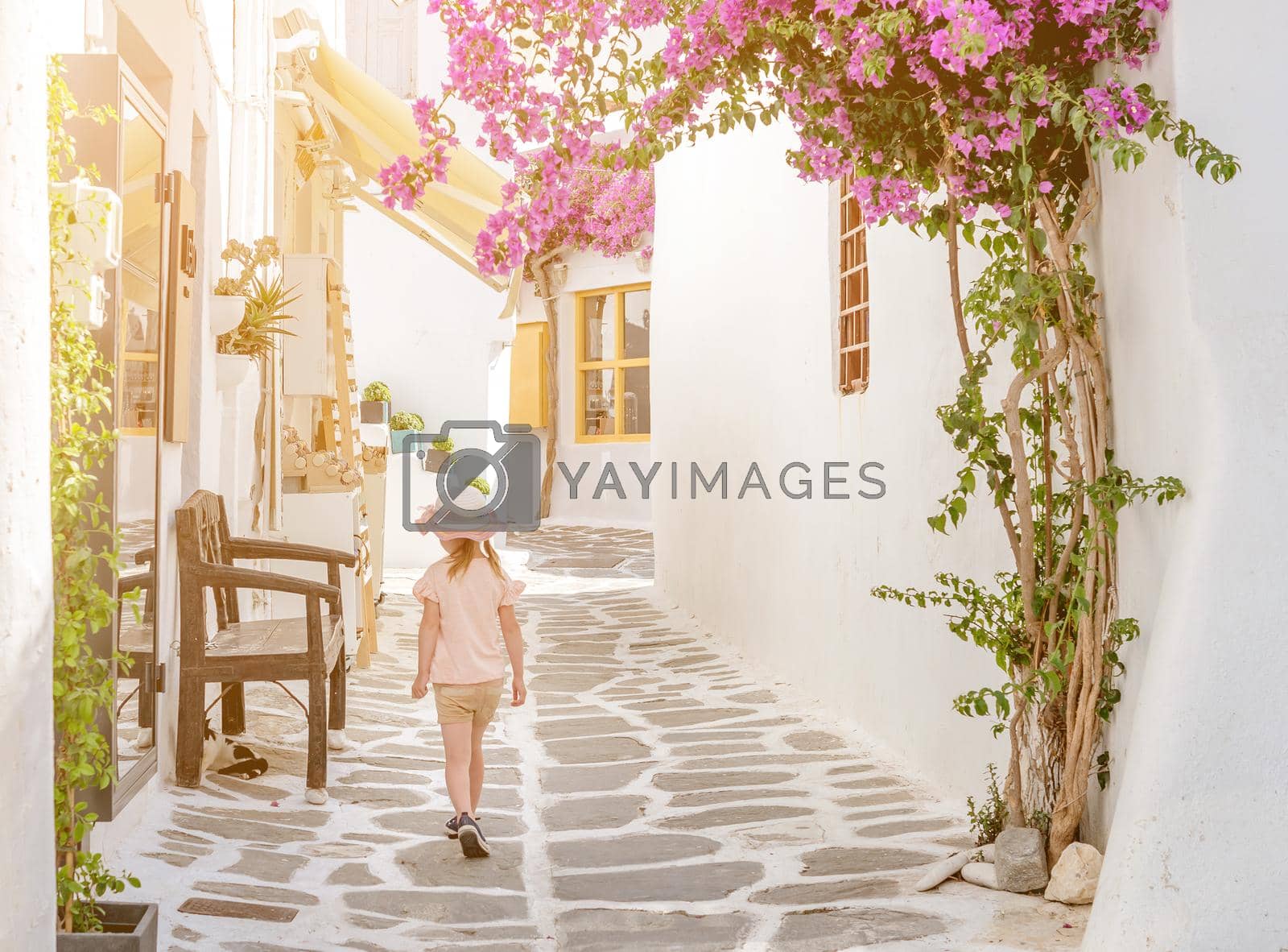 Royalty free image of Little girl walking the narrow alley in Greece by tan4ikk1