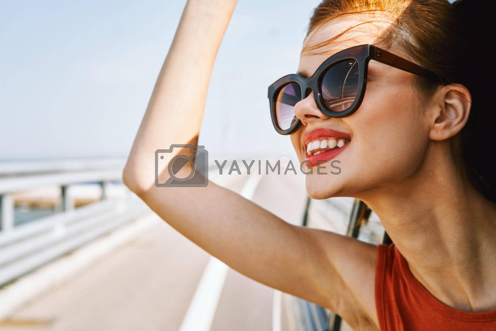cheerful woman peeking out of the car window trip adventure lifestyle. High quality photo