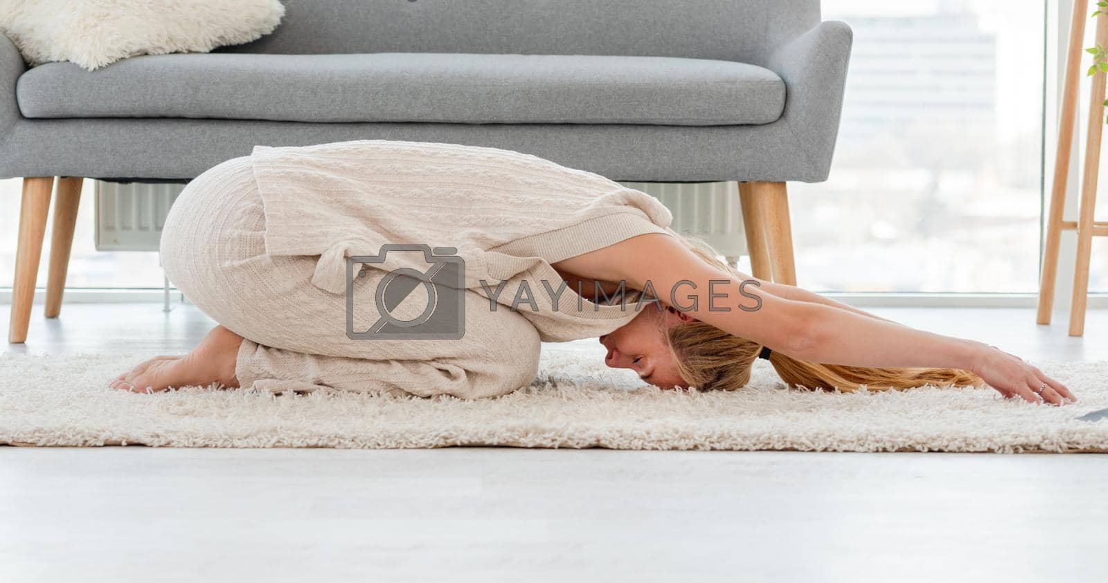 Girl staying in baby yoga pose during morning workout at home