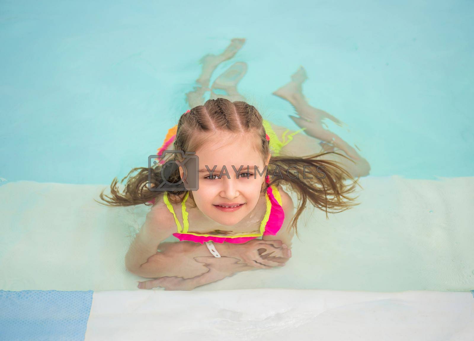 Royalty free image of Smiling girl swim to the poolside by tan4ikk1