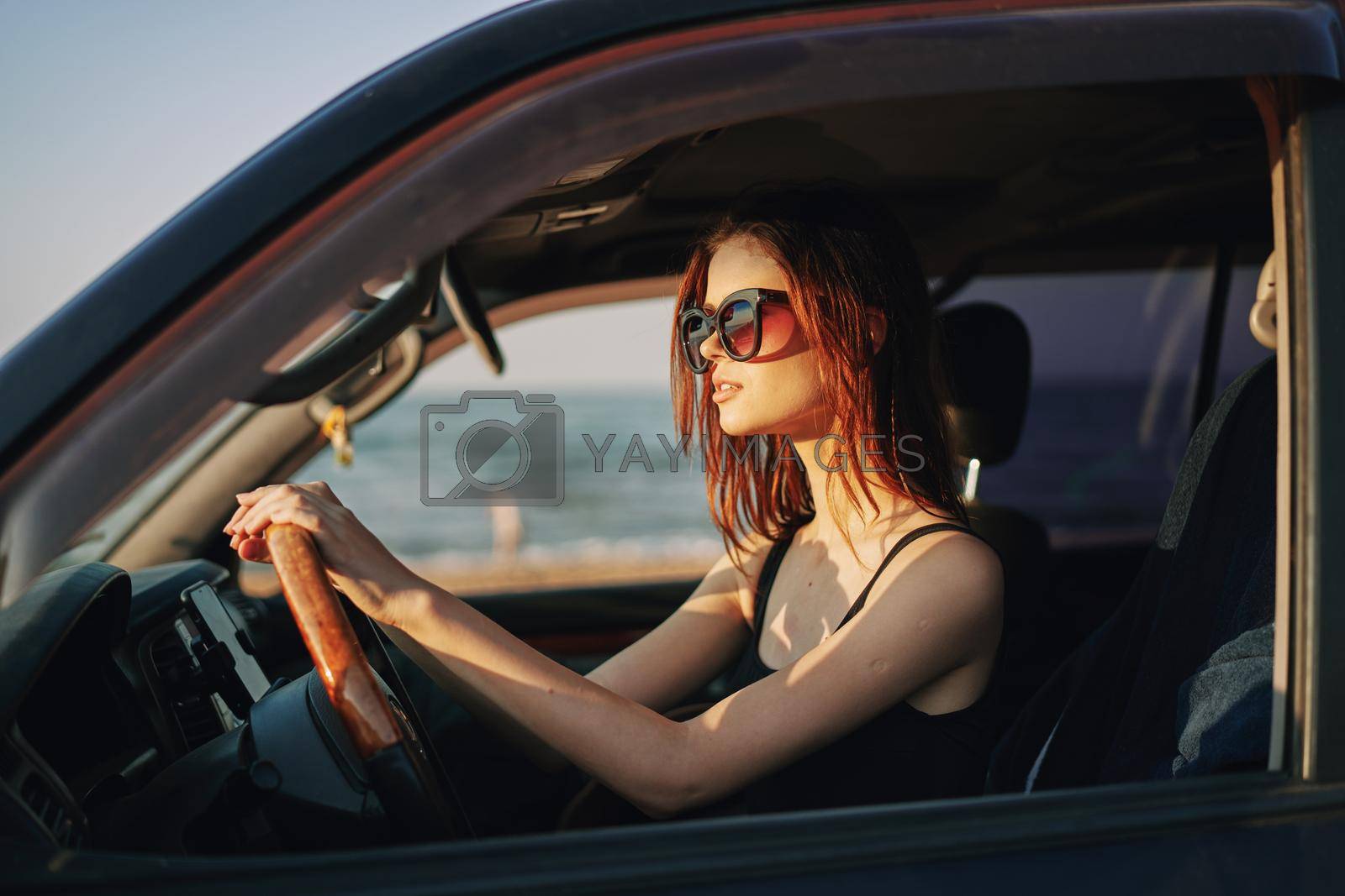 cheerful woman in sunglasses driving a car trip travel. High quality photo