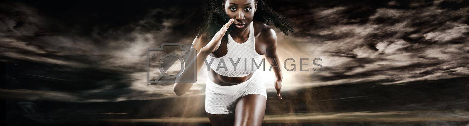A Strong athletic, female runner on the black bacground wearing a tight, fitness outfit.