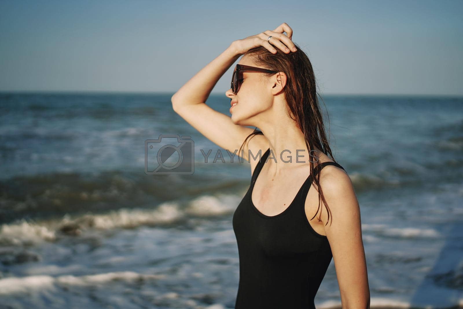 cheerful woman in black swimsuit sunglasses ocean travel. High quality photo