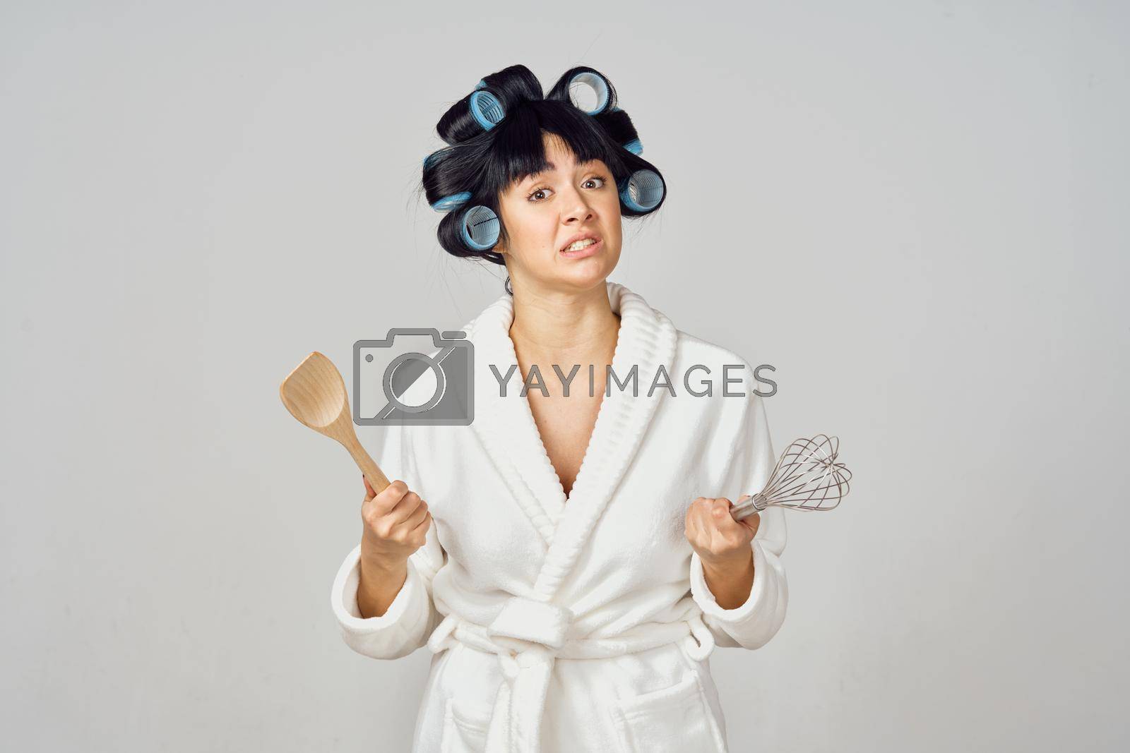Royalty free image of housewife in white robe kitchenware isolated background by Vichizh