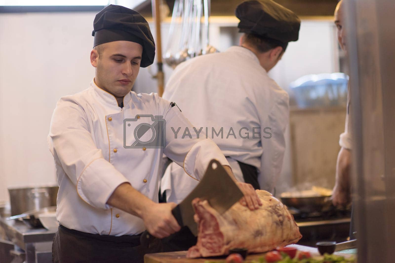 Royalty free image of chef cutting big piece of beef by dotshock