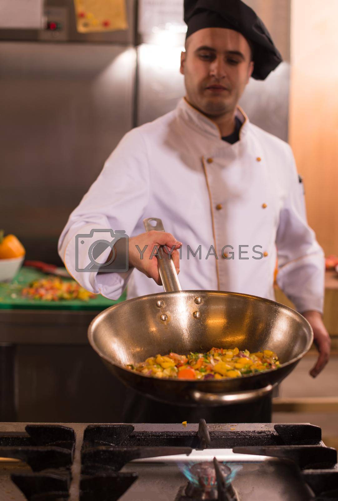 Royalty free image of chef flipping vegetables in wok by dotshock