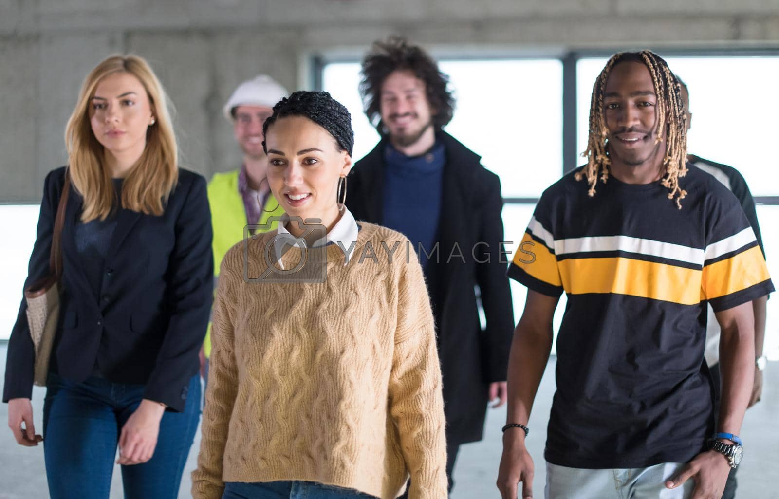 Royalty free image of young multiethnic business people walking through unfinished startup office by dotshock