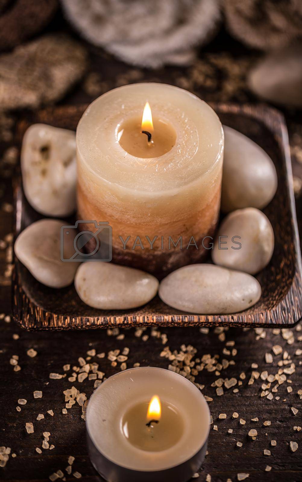 Spa relaxation setting with candle and stones