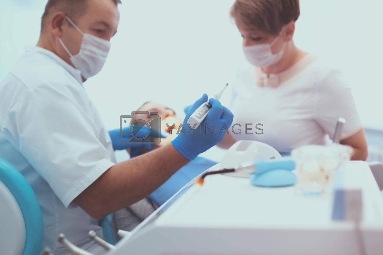 Detail of hand holding dental tools in dental clinic. Dentist Concept.
