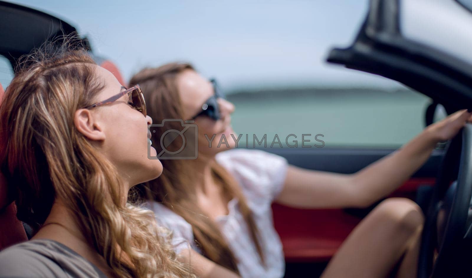 Royalty free image of young women in a convertible car. by asdf