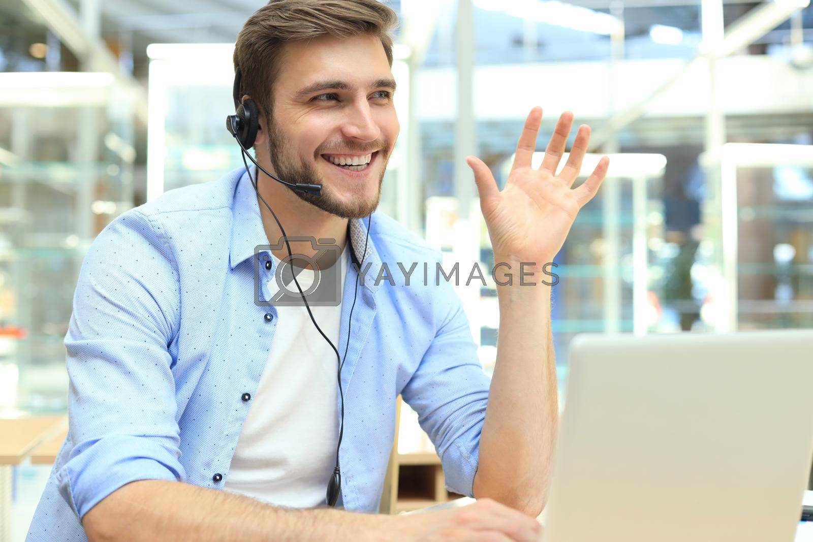 Royalty free image of Happy young male customer support executive working in office. by tsyhun