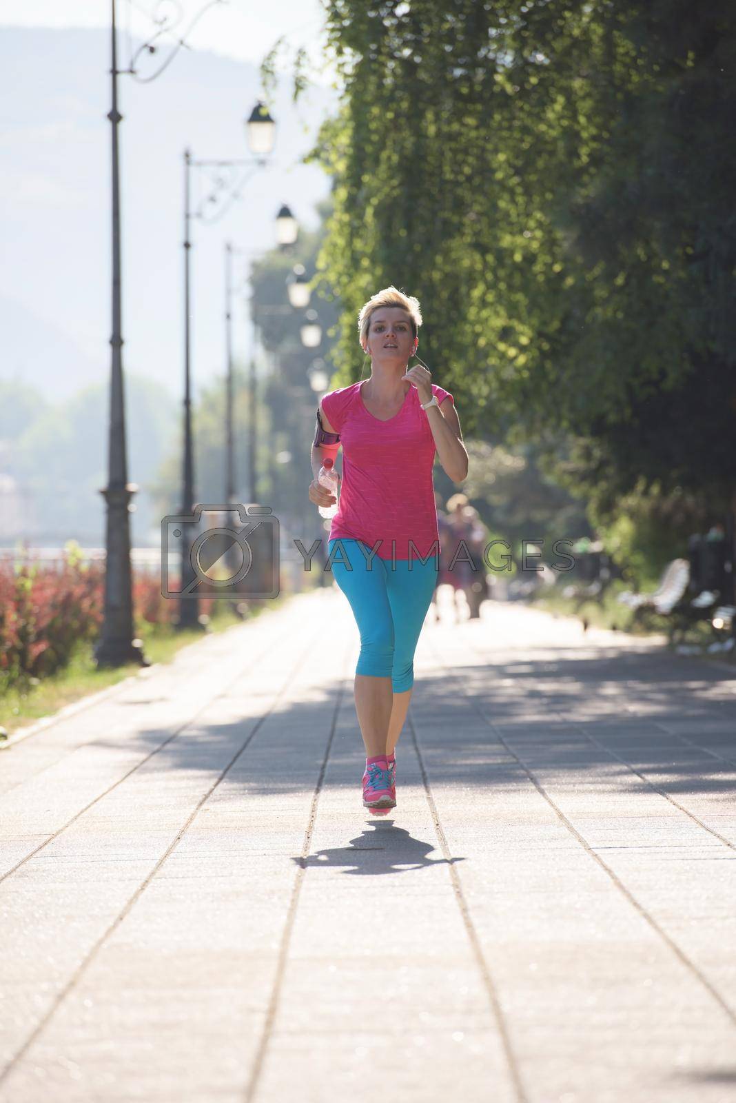 Royalty free image of sporty woman running  on sidewalk by dotshock