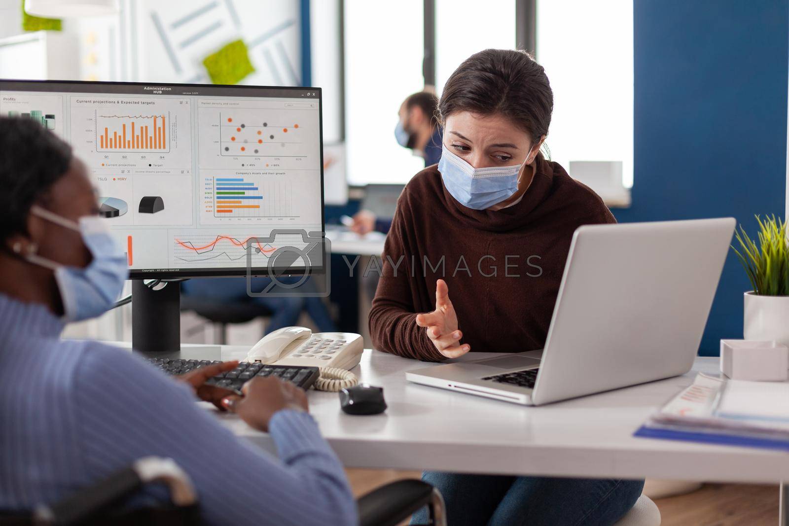 Royalty free image of Multi-ethnic business team with protective face masks against coronavirus by DCStudio