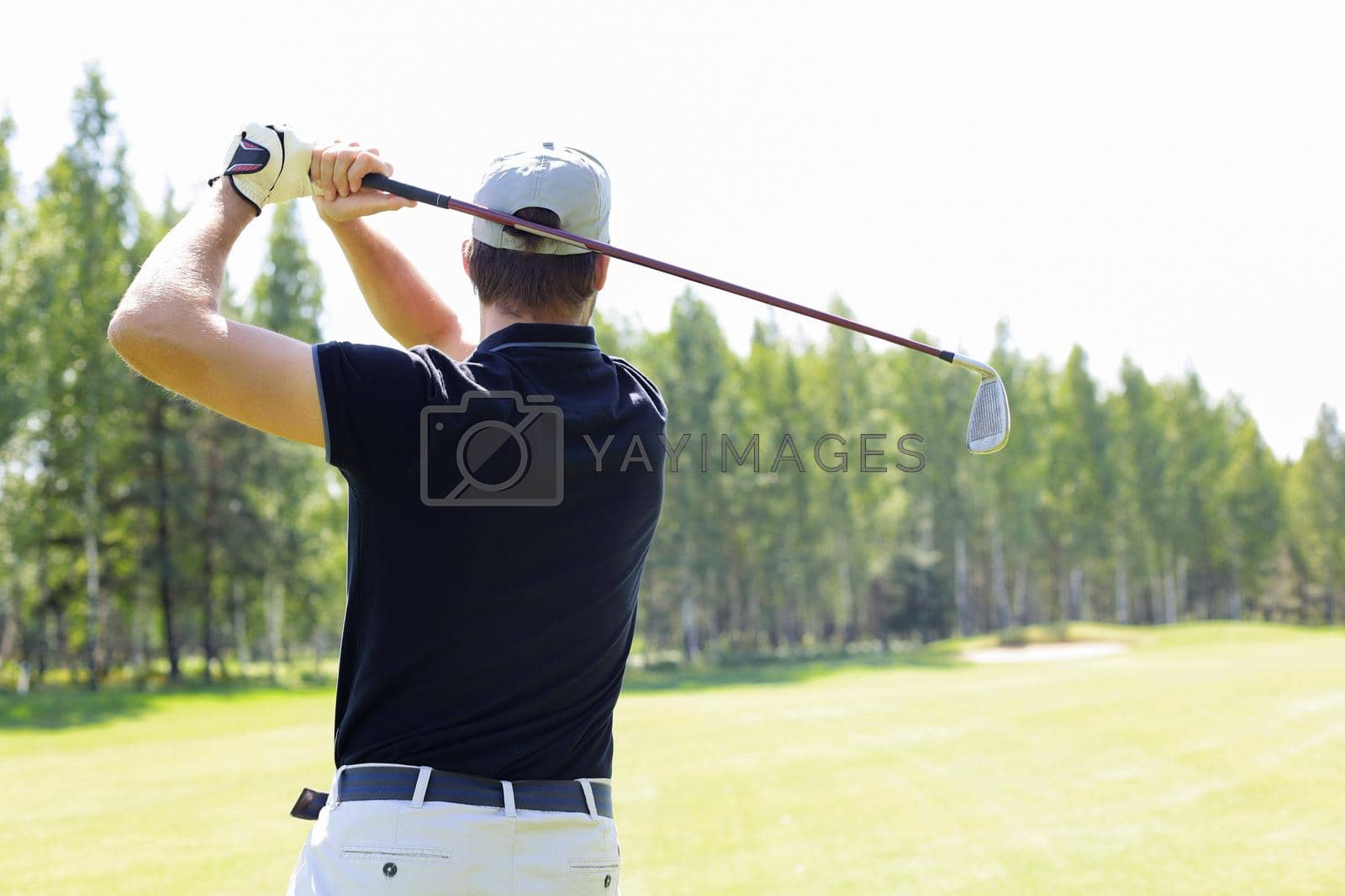 Royalty free image of Golfer hits an fairway shot towards the club house. by tsyhun