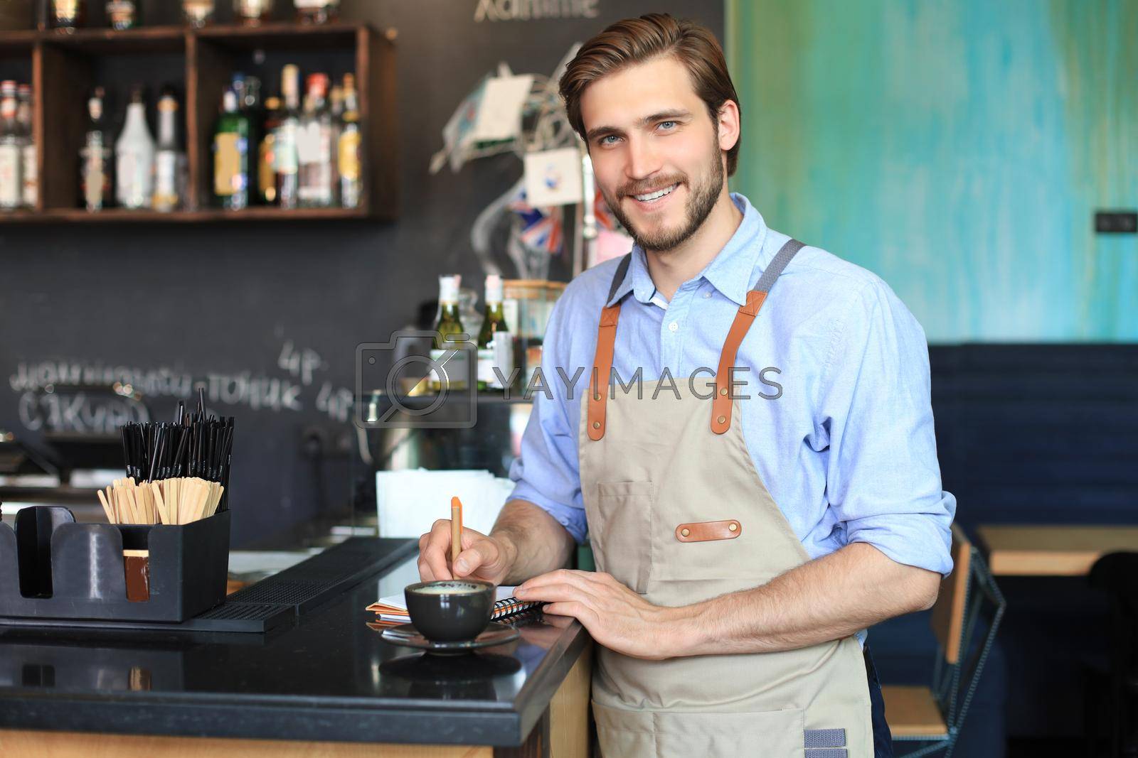 Royalty free image of Small business owner working at his cafe. by tsyhun