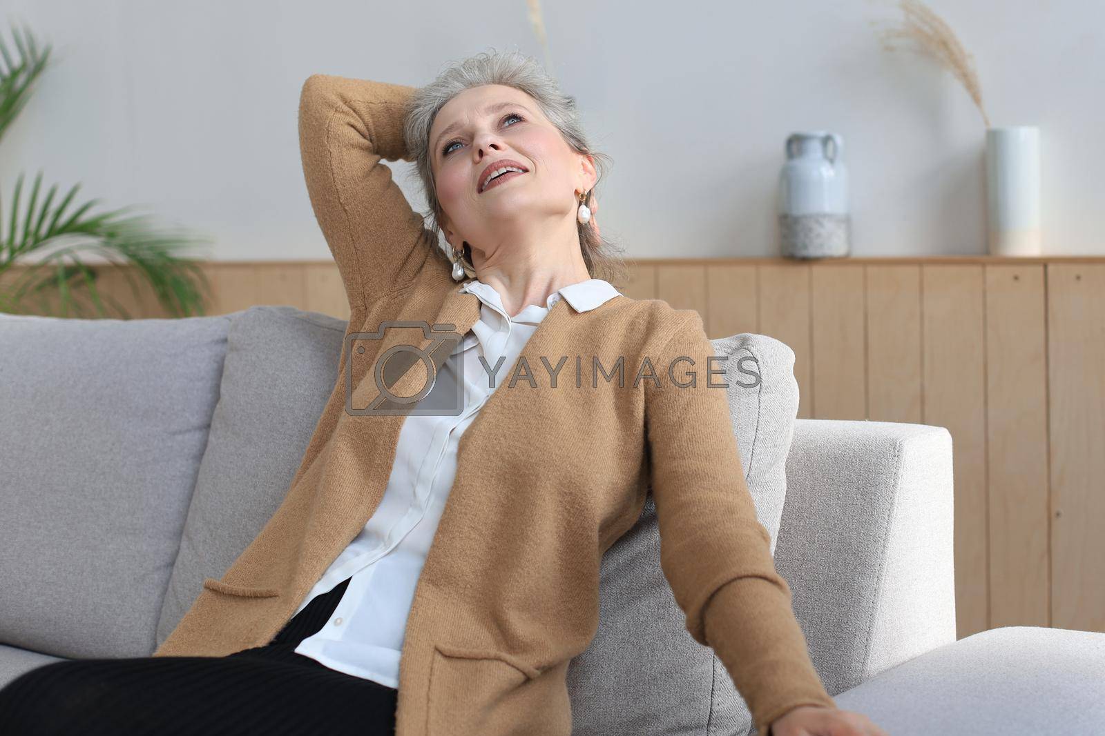 Royalty free image of Attractive middle aged woman relaxing in sofa at home. by tsyhun