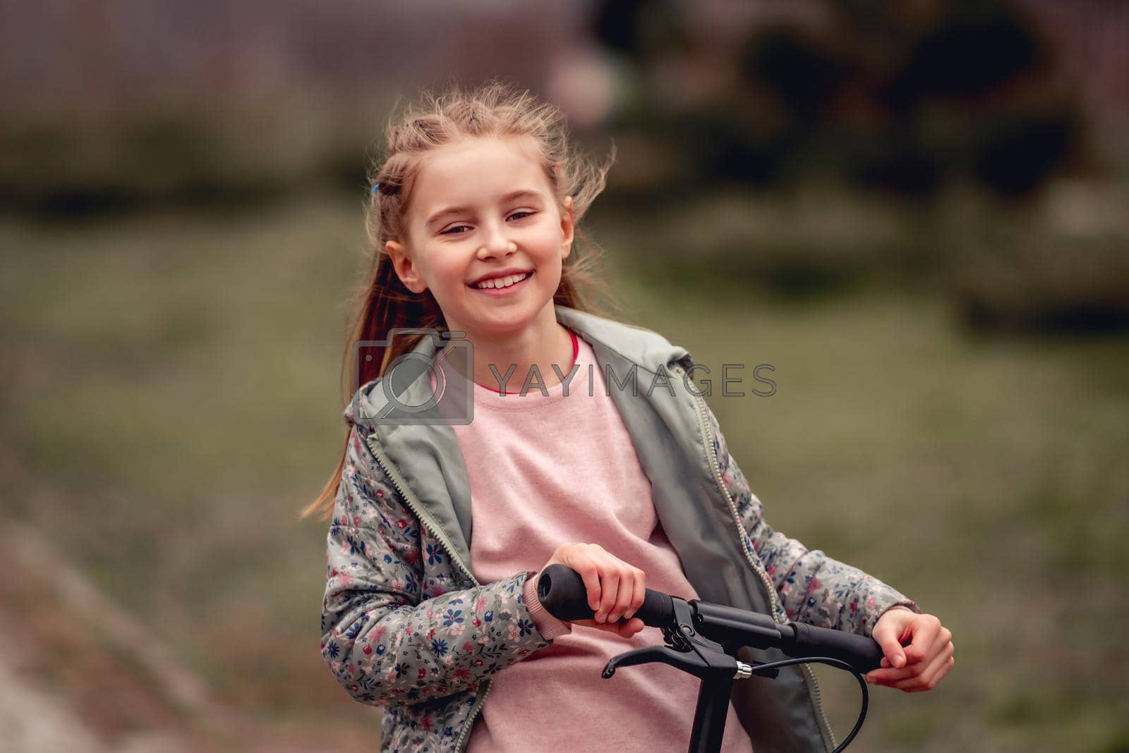 Royalty free image of Little girl with scooter by tan4ikk1