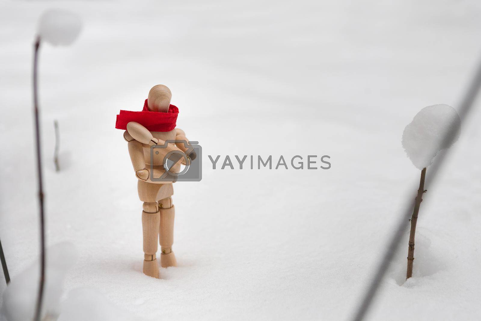 Royalty free image of Small wooden puppet in snowdrift by Prostock-studio