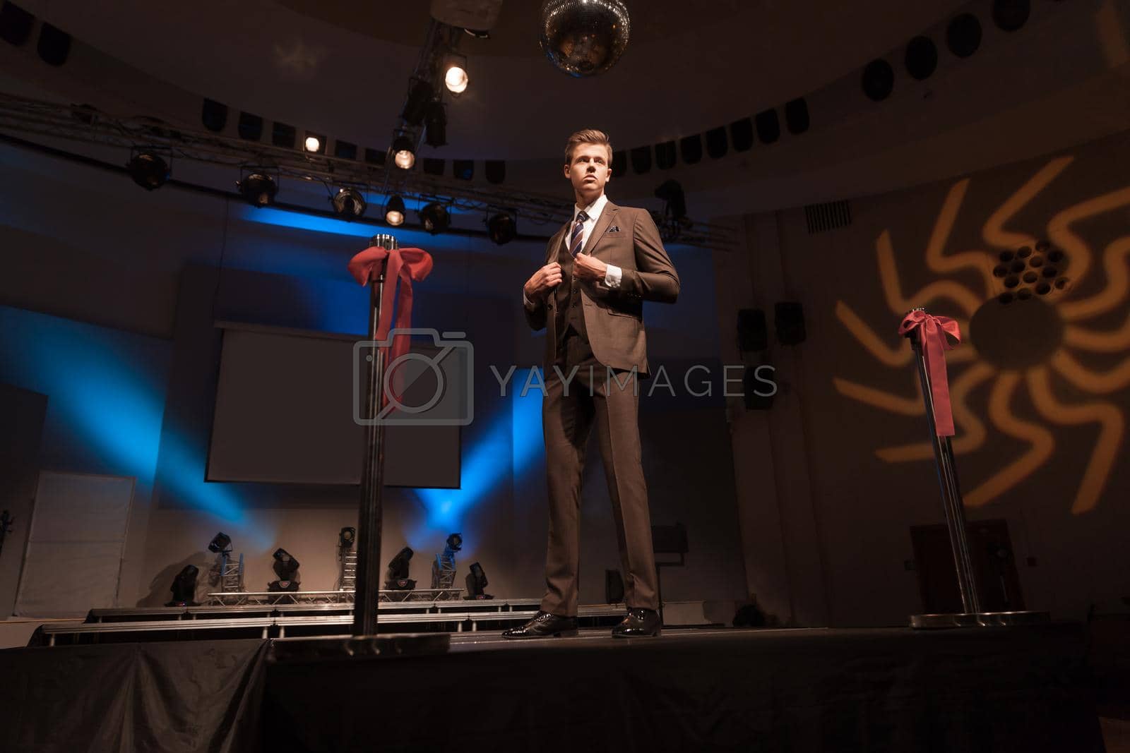 confident male model showing off business suit during fashion show