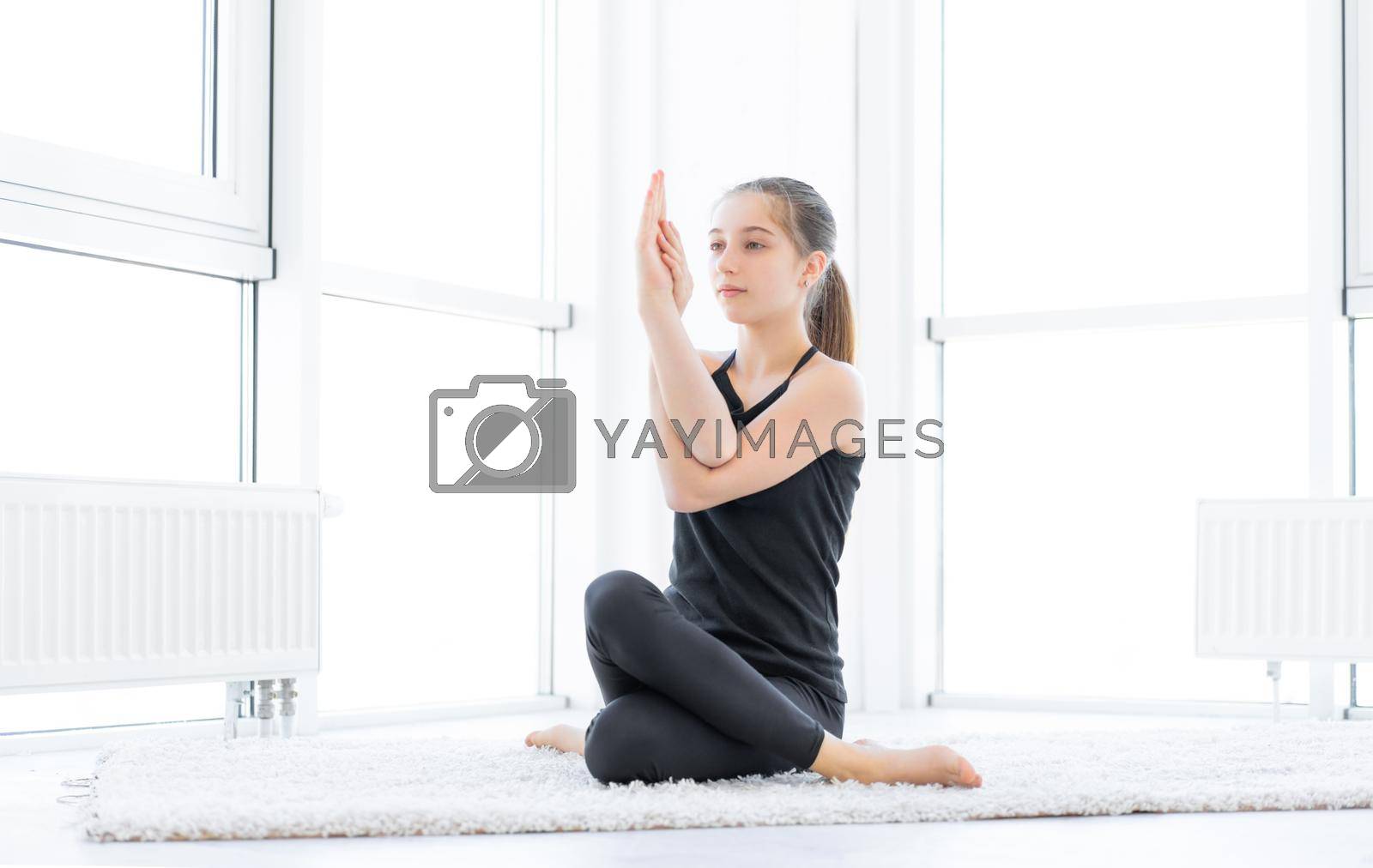 Beautiful girl doing yoga asana in bright room