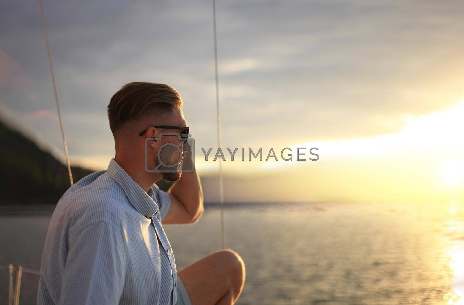 Royalty free image of relaxing man sitting on boat sailing on sea happy and carefree. by tsyhun
