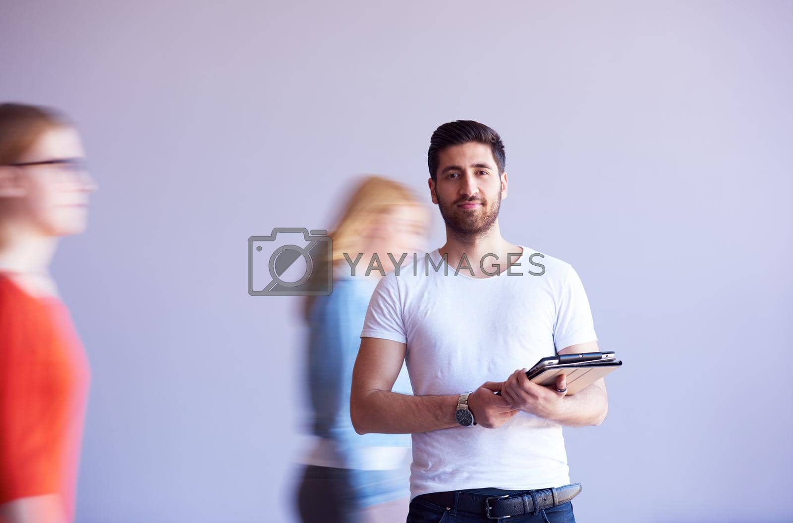 Royalty free image of student working on tablet, people group passing by by dotshock