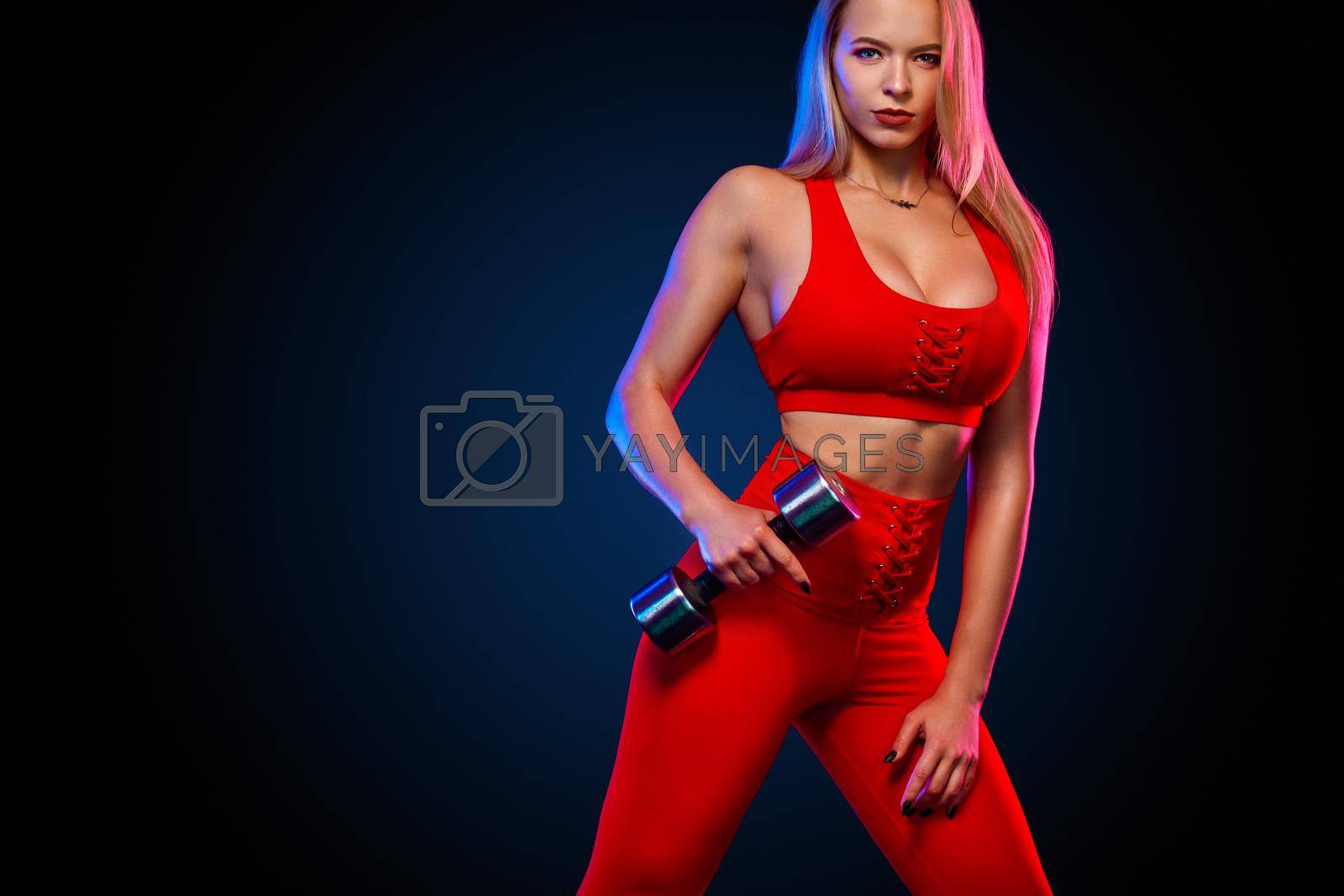 Sporty fit woman, athlete with dumbbells makes fitness exercising on black background with lights.