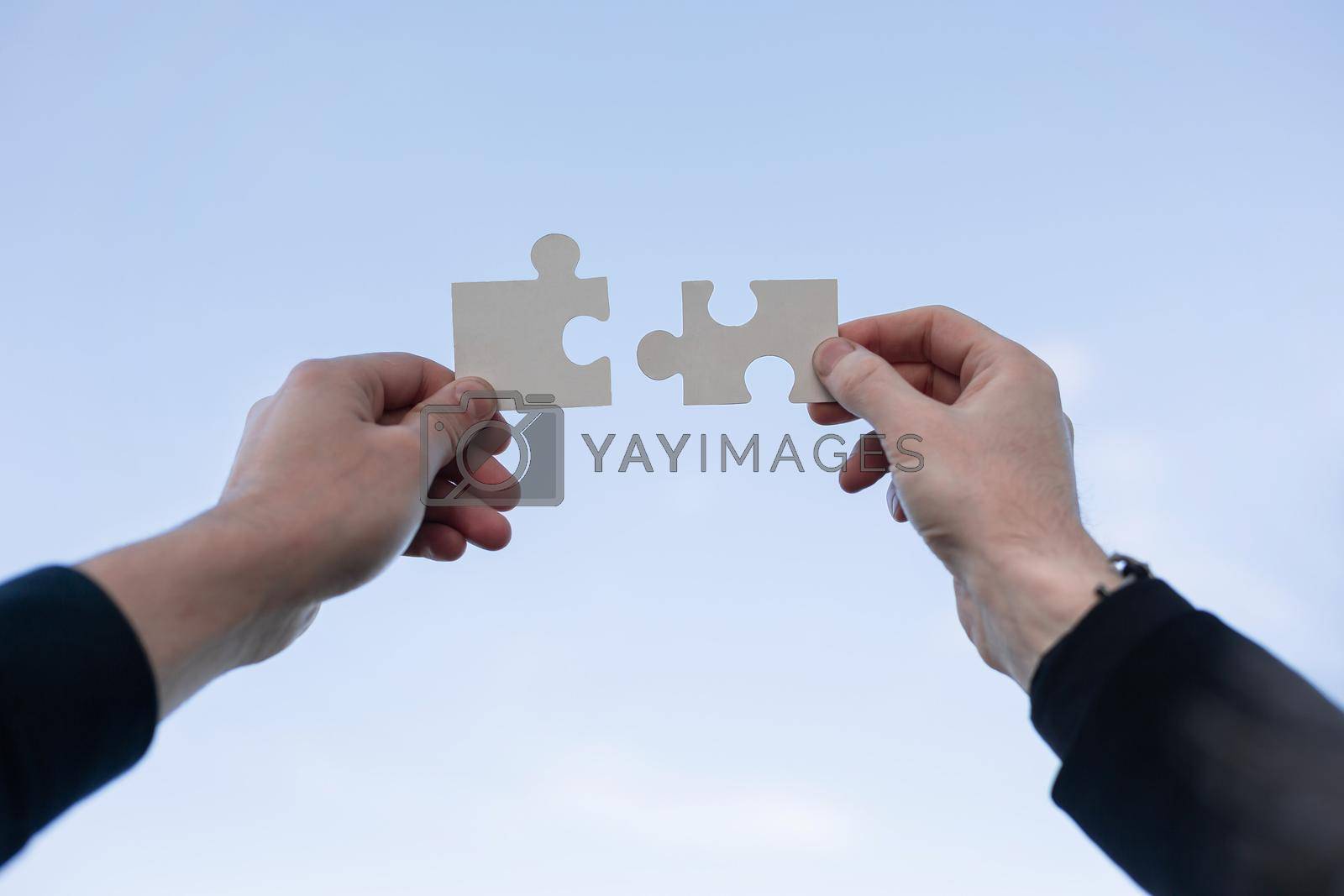 Royalty free image of two 2 hands trying to connect couple puzzle piece by asdf