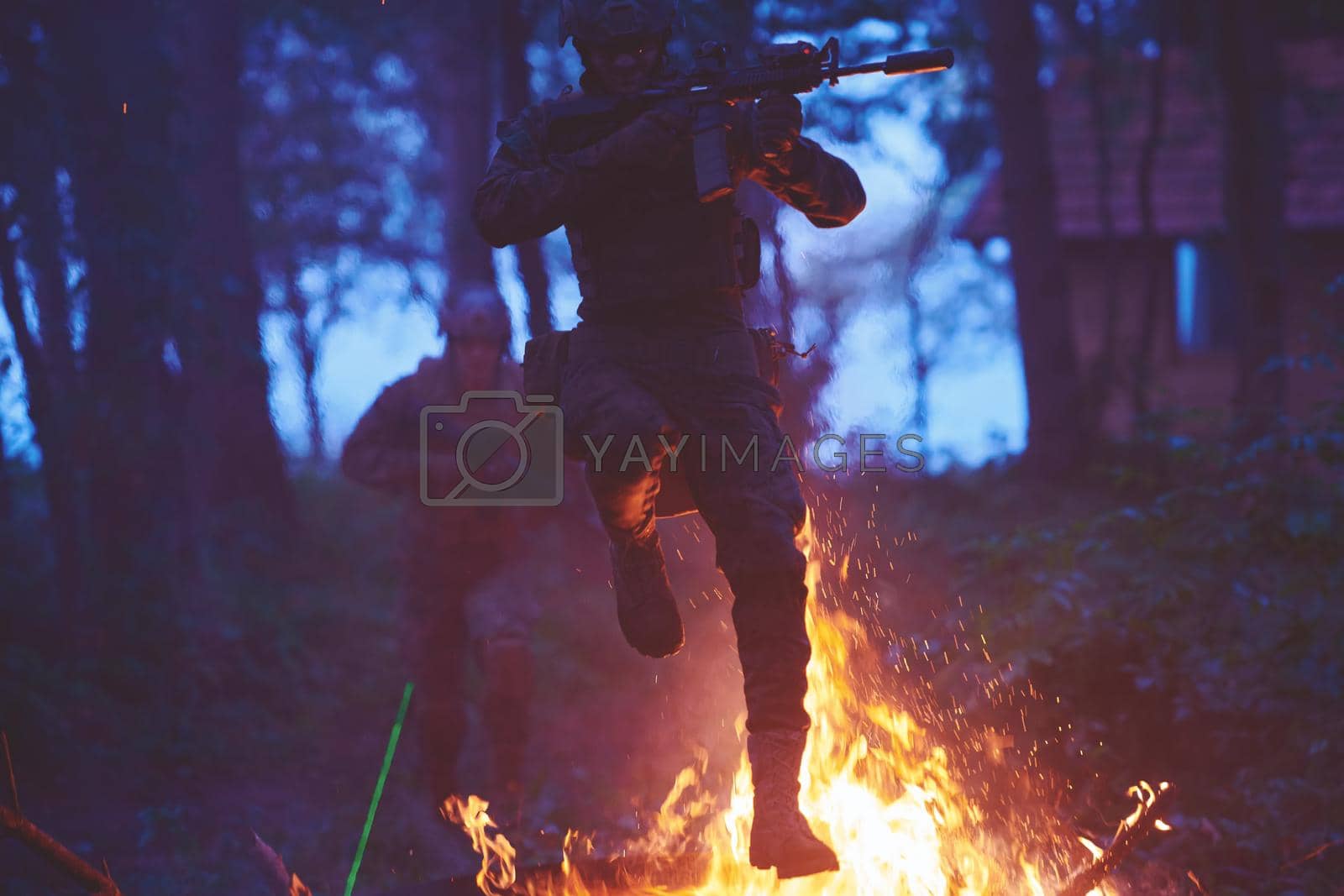 Royalty free image of Soldier in Action at Night jumping over fire by dotshock
