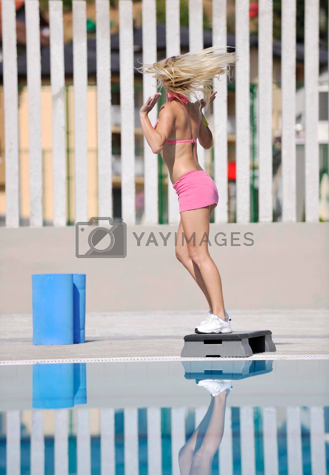Royalty free image of woman fitness exercise at poolside by dotshock