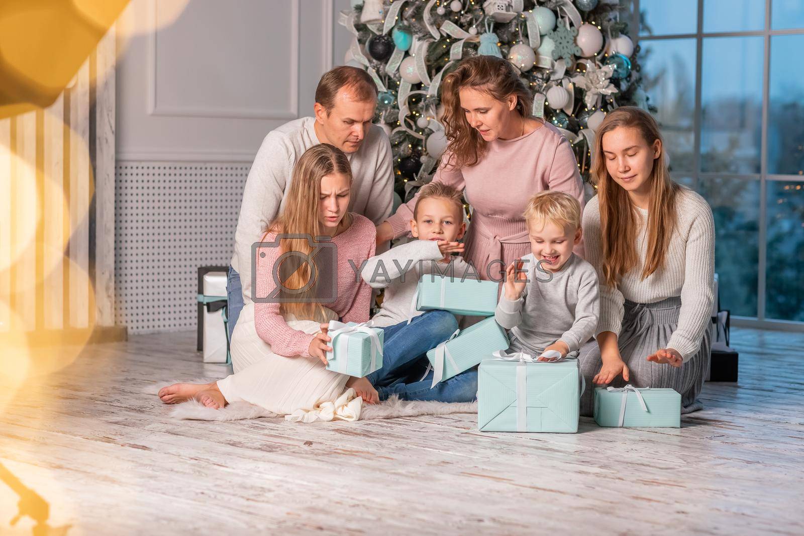 Royalty free image of Big happy family with many kids opening presents under the Christmas tree on Christmas eve by Len44ik