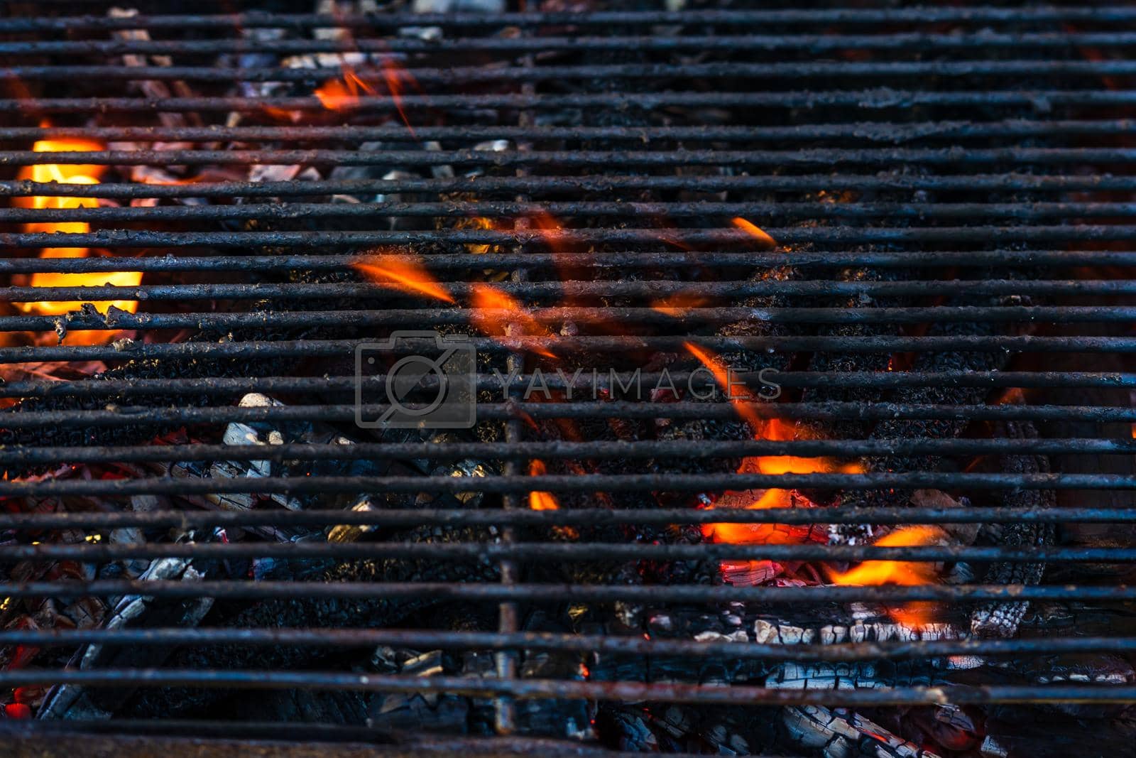 Royalty free image of Empty hot charcoal barbecue grill with bright flame. Hot burning grill, outdoors cooking food by vladispas