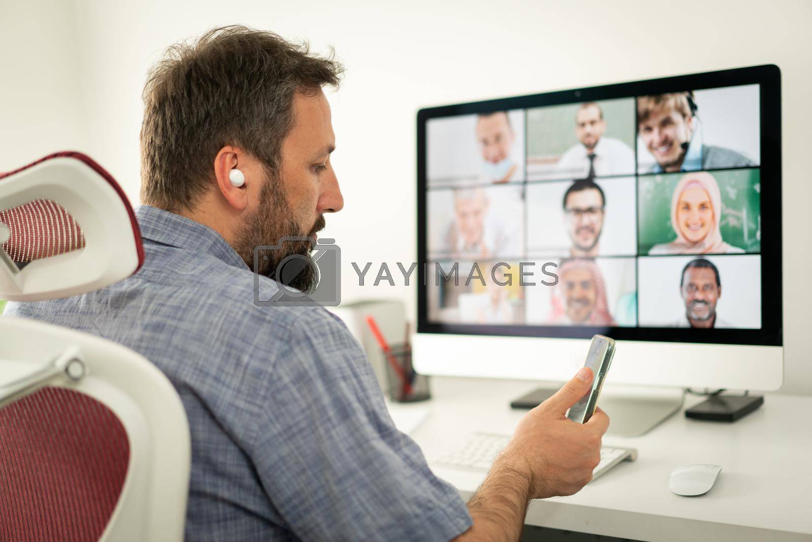 Royalty free image of Mid adult man having online conference working from home by Zurijeta