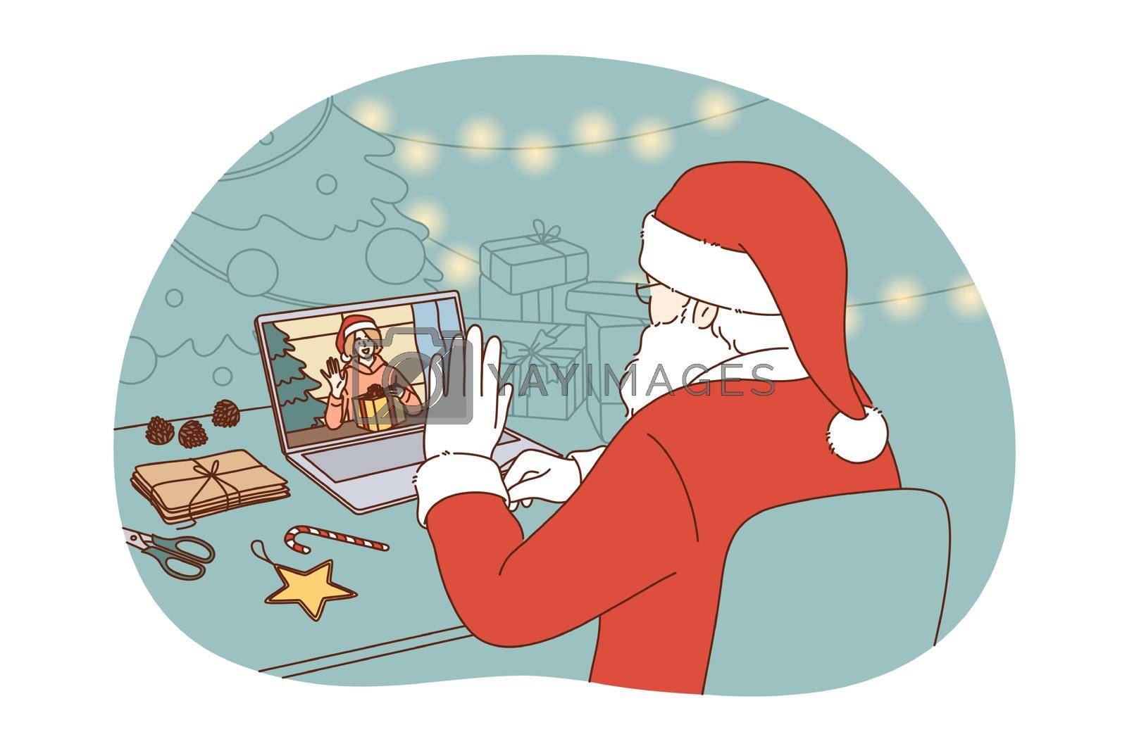 Online Christmas and New year celebration concept. Santa Claus in traditional red costume sitting and congratulating happy child with winter holidays online on laptop during video call distant meting