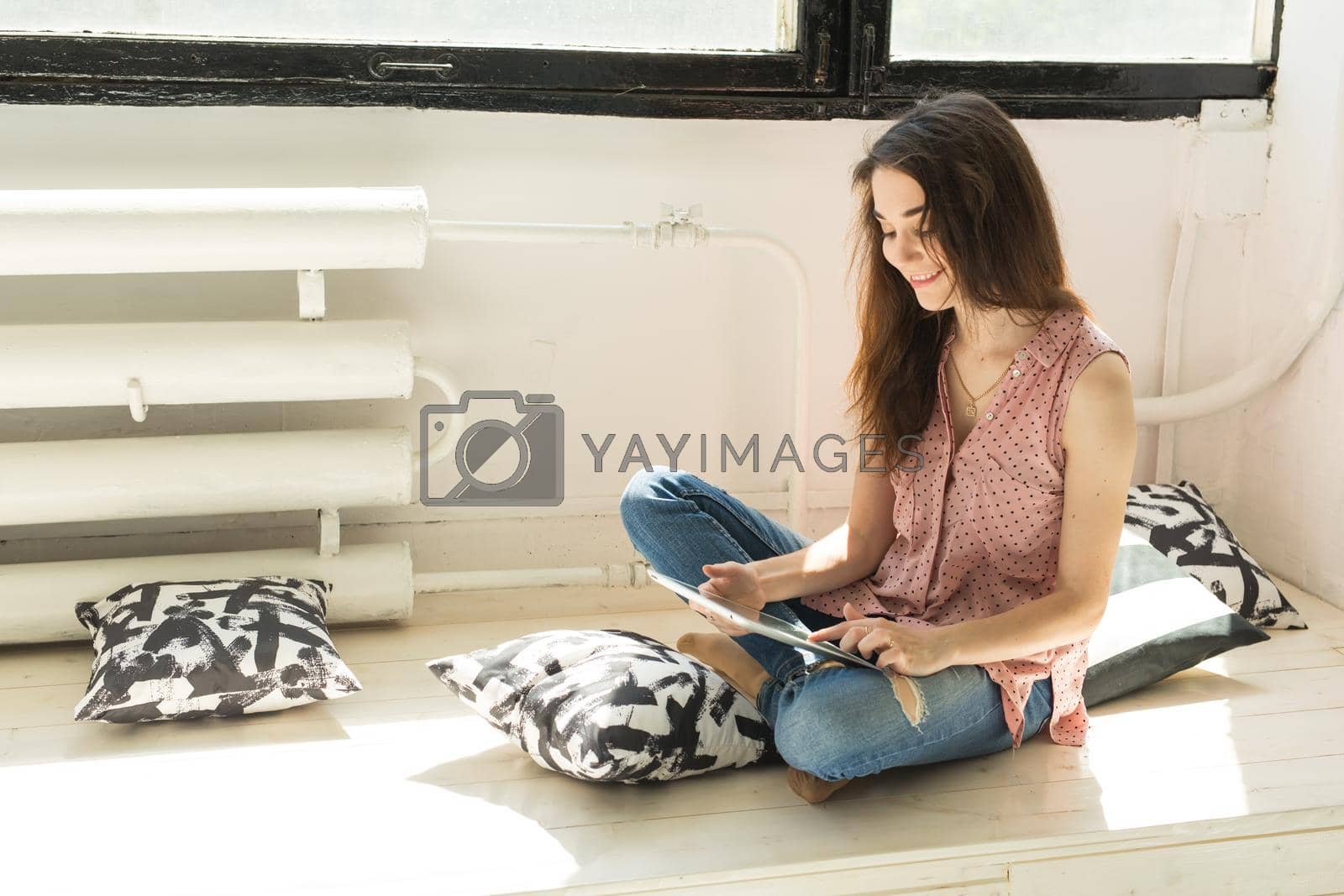 Royalty free image of Leisure, technology and people concept - young brunette woman using tablet at home by Satura86
