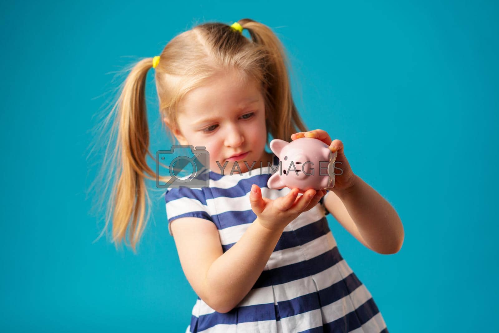 Royalty free image of Funny little girl with piggy bank moneybox portrait by Fabrikasimf