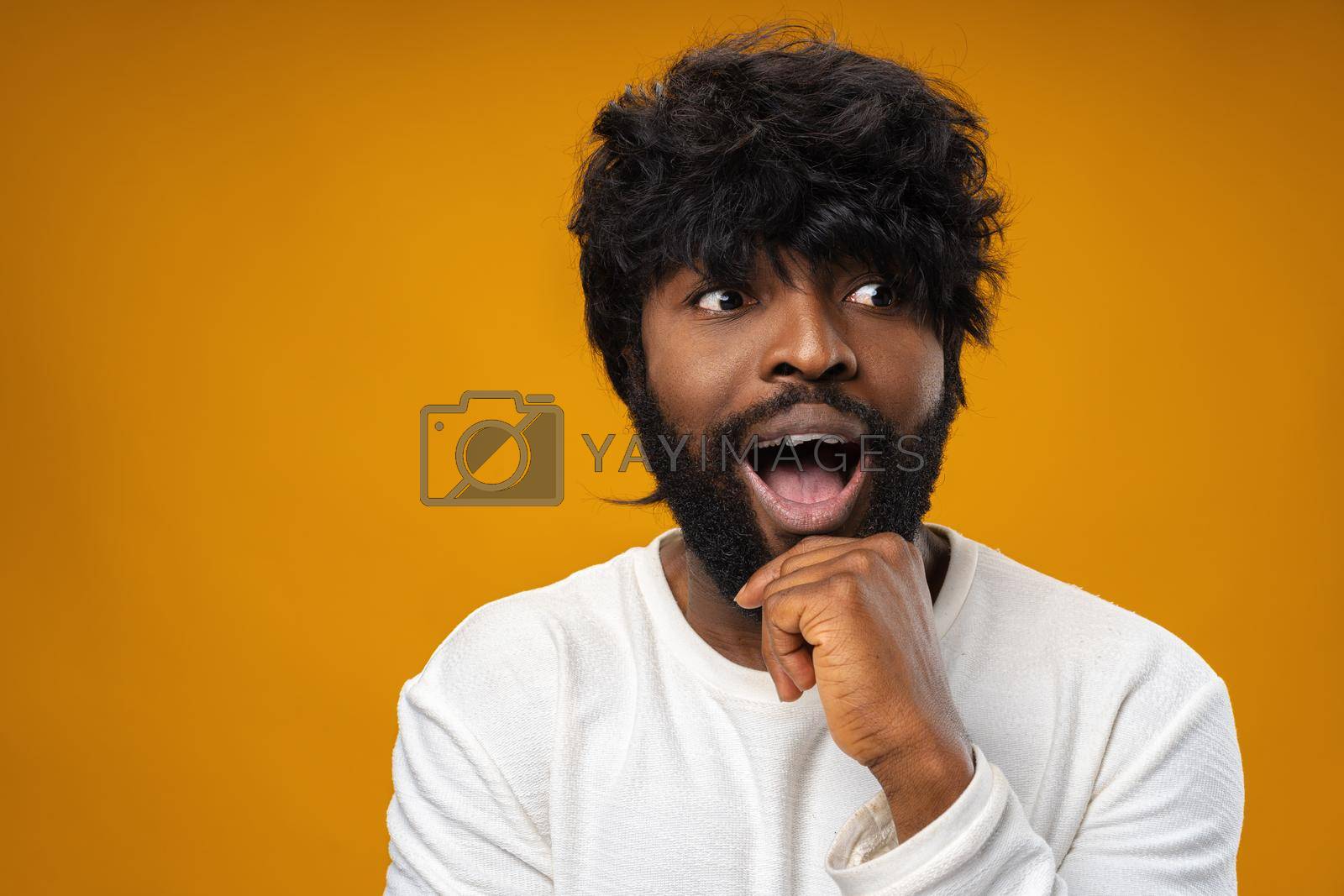 Royalty free image of Young african american man looking surprised with open mouth by Fabrikasimf