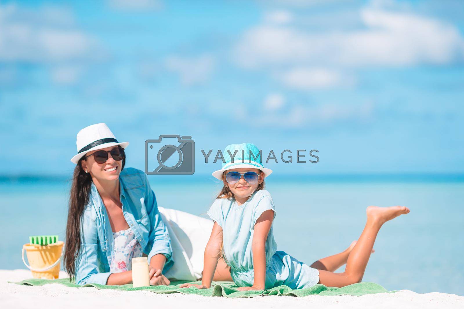 Family of mother and little girl on tropical beach