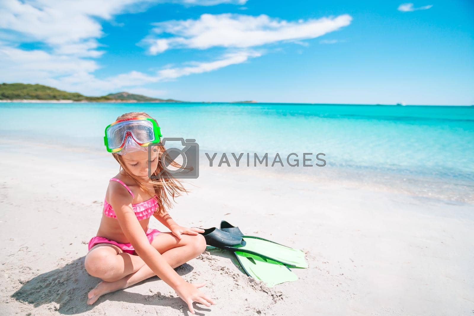 Royalty free image of Little girl with flippers and goggles for snorkling on the beach by travnikovstudio